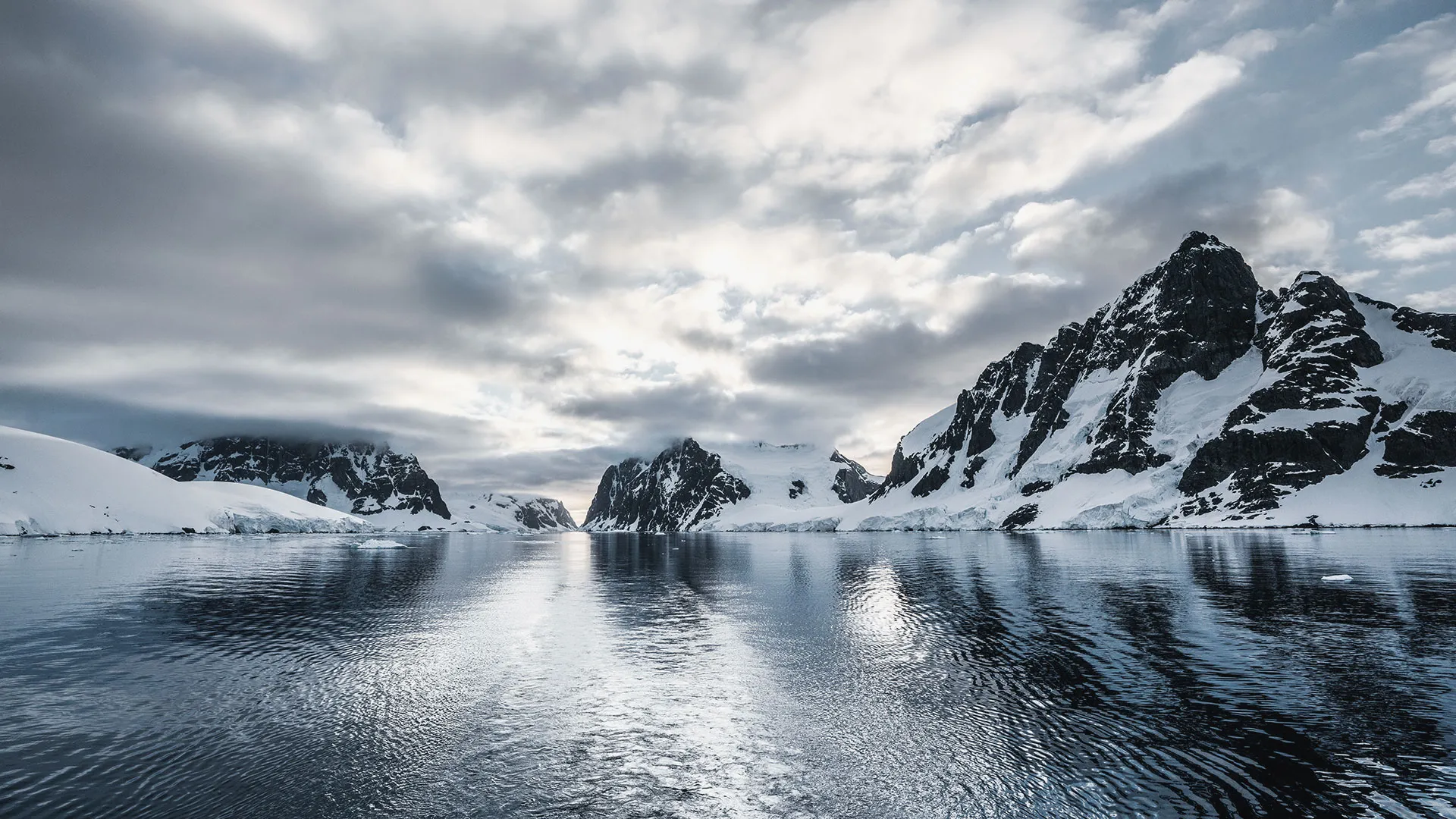 Antarctic coastline — peaks mirrored in still, dark water
