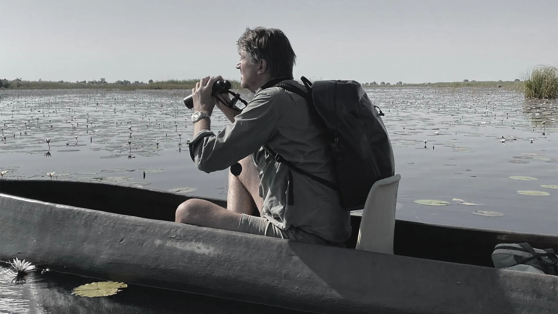 Photographer working from a low aluminium dinghy on the delta