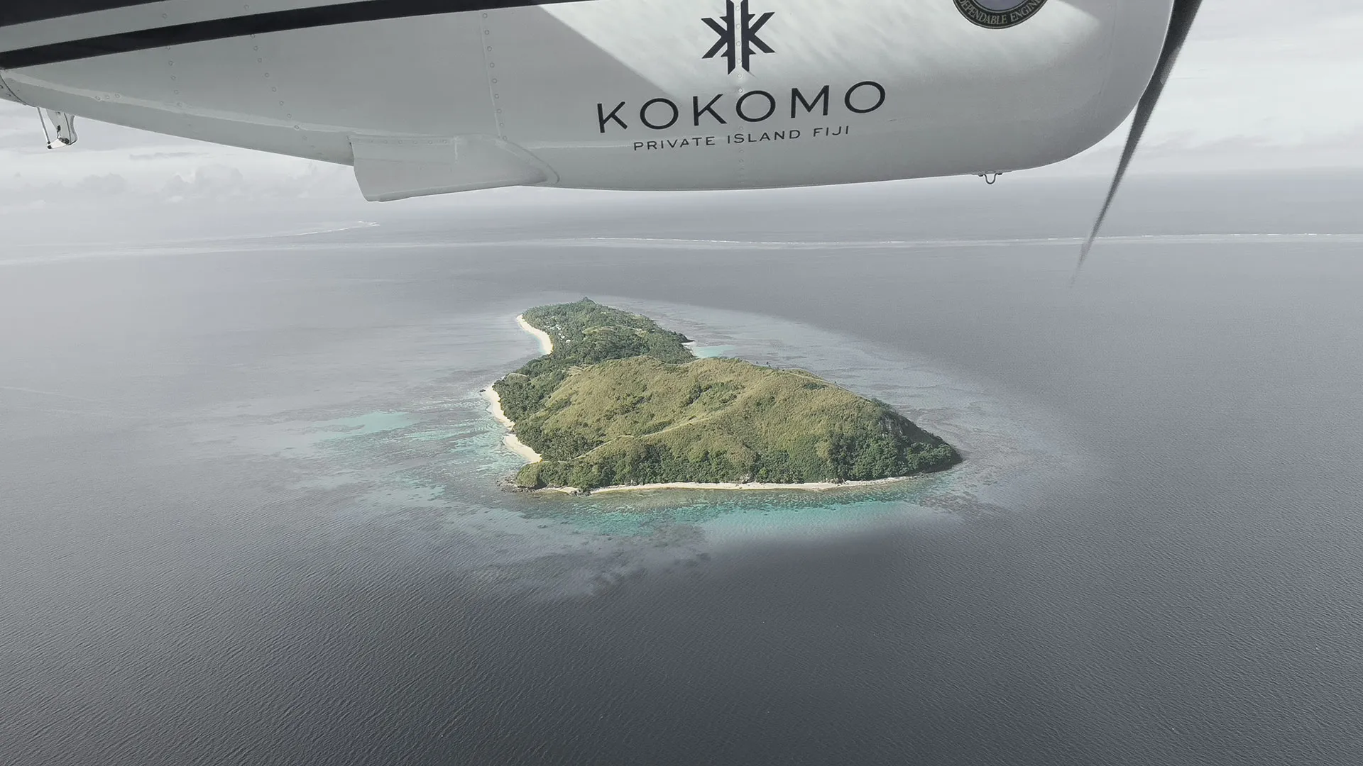 Aerial of a small Fijian island ringed by turquoise reef