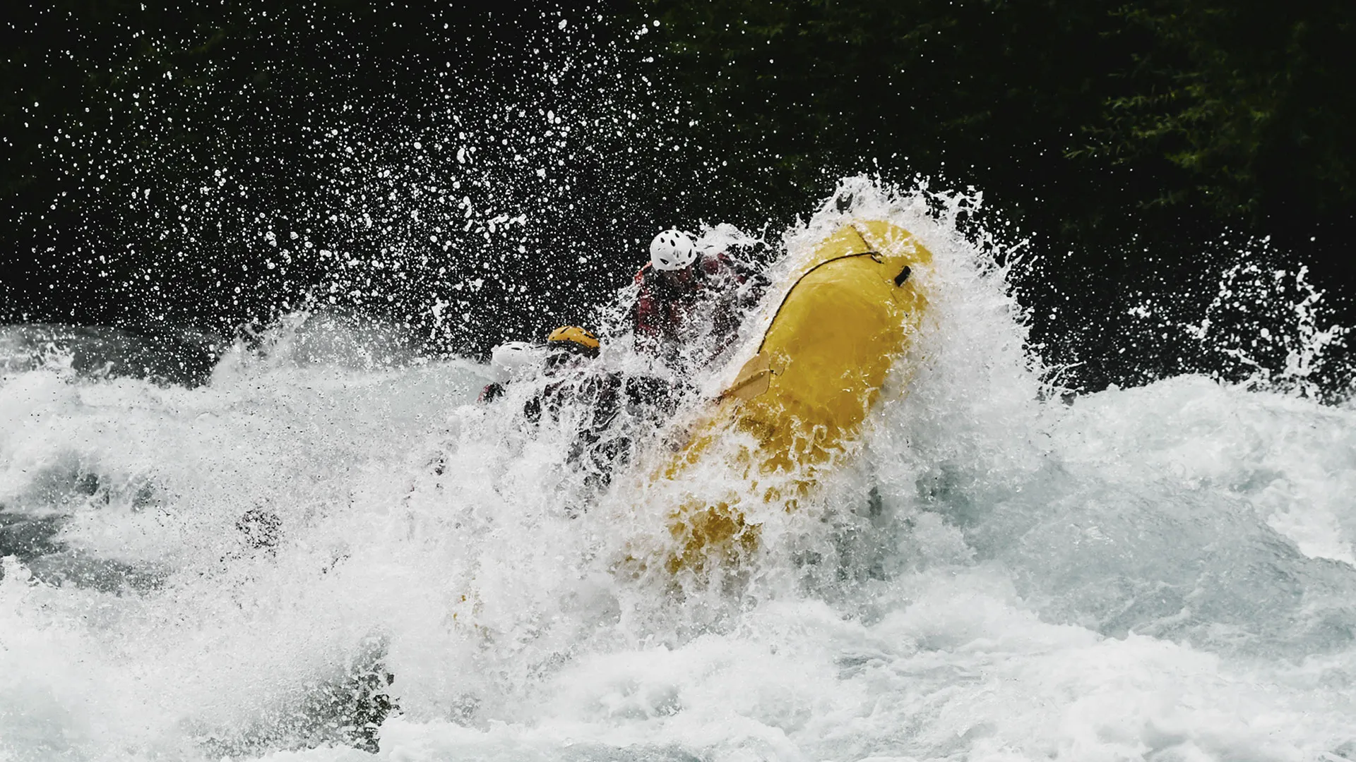 Yellow raft punching through a Class V rapid on the Futaleufú River