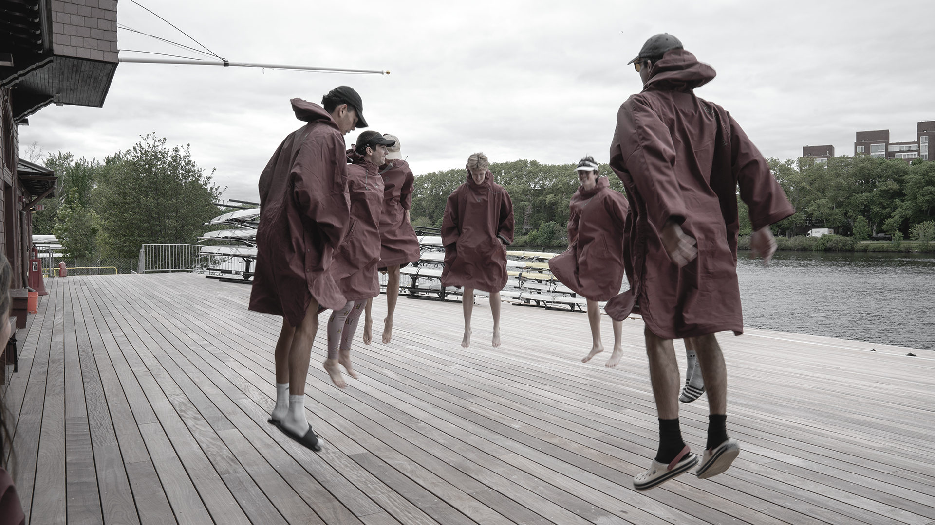 A rowing crew in CHALK Storm ponchos on the water at first light